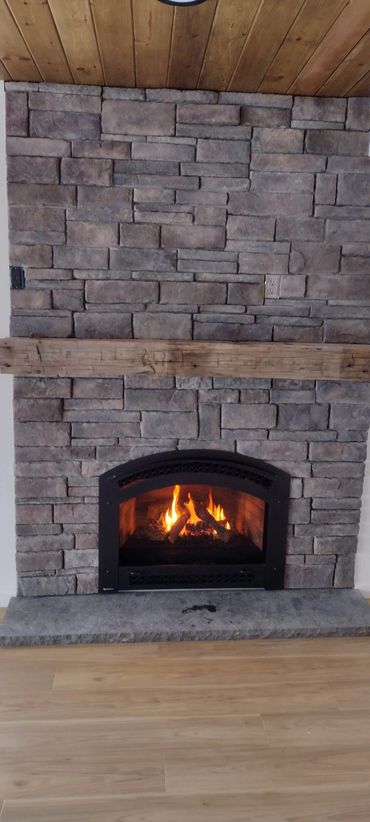 a professionally installed stone wall with a gas fireplace insert
