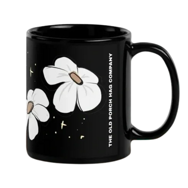 A minimalist black mug featuring a simple daisy illustration.