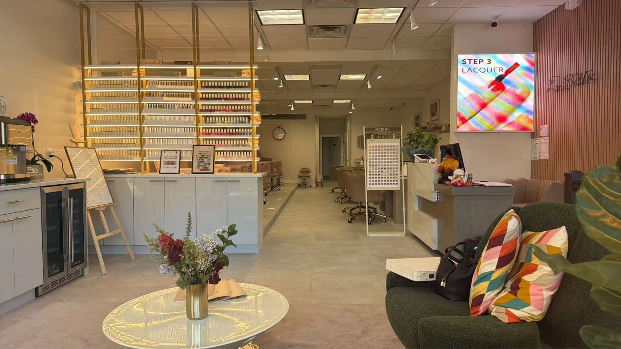 Modern nail salon interior with organized nail polish display and cozy seating.