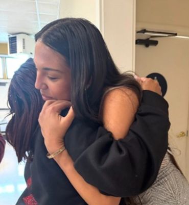 Two people sharing a heartfelt hug indoors.