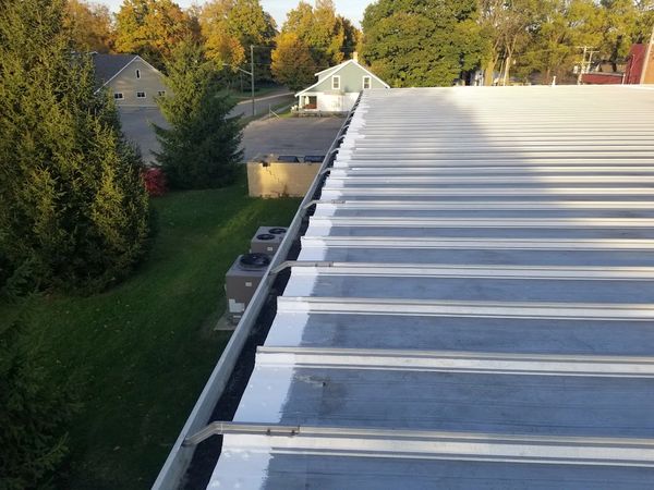 Metal roof Edge and roof fasteners have been sealed using a high solids silicon roof coating.