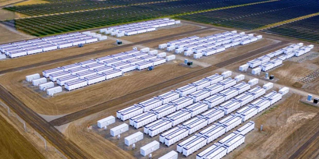 Aerial view of rows of large white containers on a dry land field.
