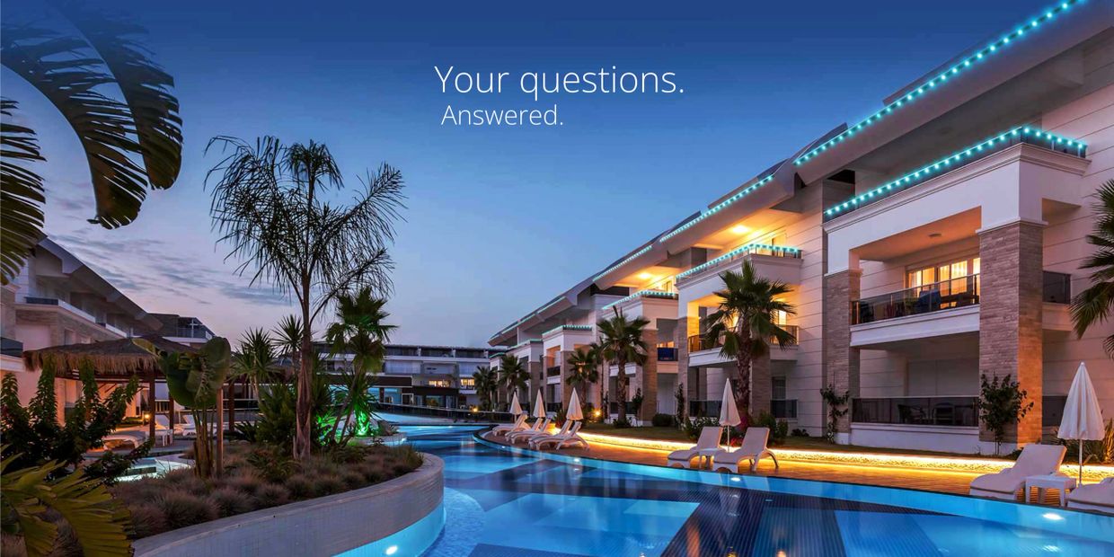Luxurious resort poolside at dusk with illuminated buildings and palm trees.