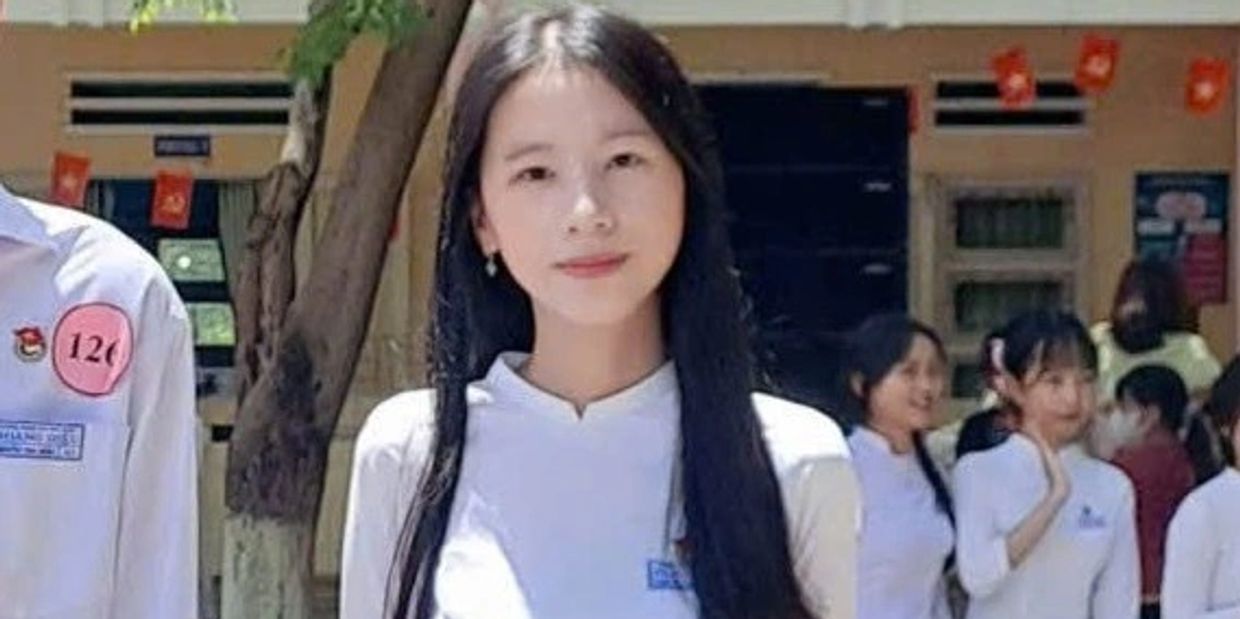 Young woman in white traditional dress outdoors.
