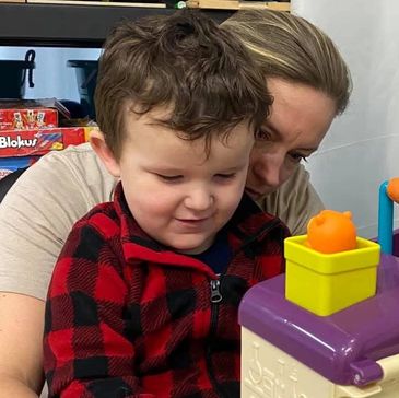 Adult and child playing with a colorful toy together.