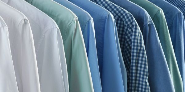 Row of hanging shirts in various blue and white shades.