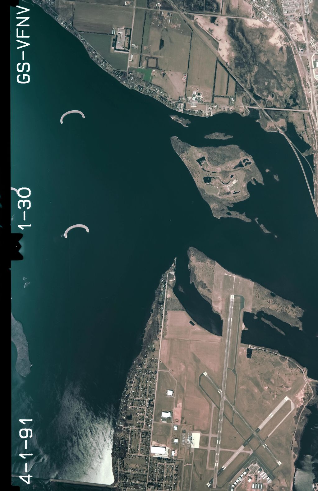 Aerial view of an airport surrounded by water and land.