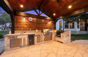 Custom covered outdoor kitchen with built-in grill and stone countertops in Southlake , Texas