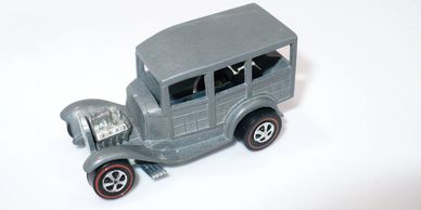 Gray vintage toy car model with exposed engine.
