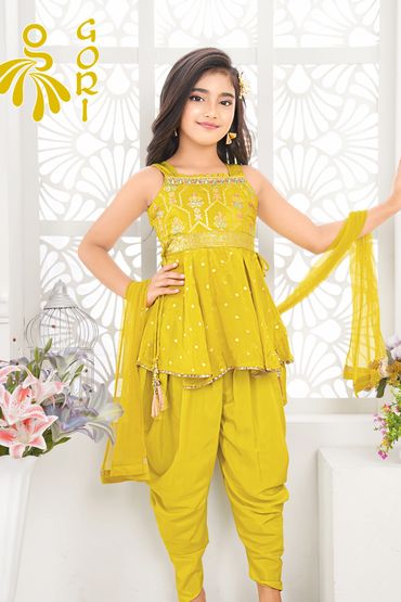 Young girl in a traditional green ethnic outfit posing confidently.