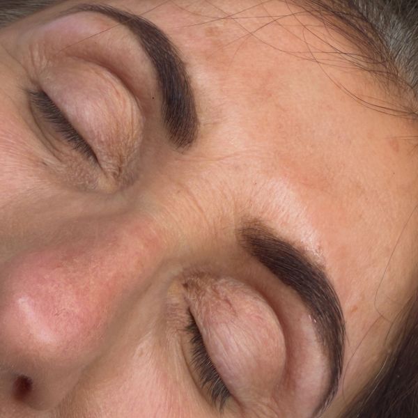 Close-up of closed eyes with well-groomed, shaped eyebrows.