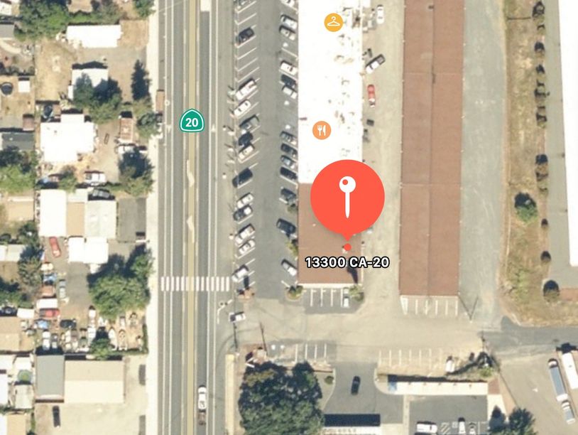 Aerial view of 13300 CA-20 with parking and nearby buildings.