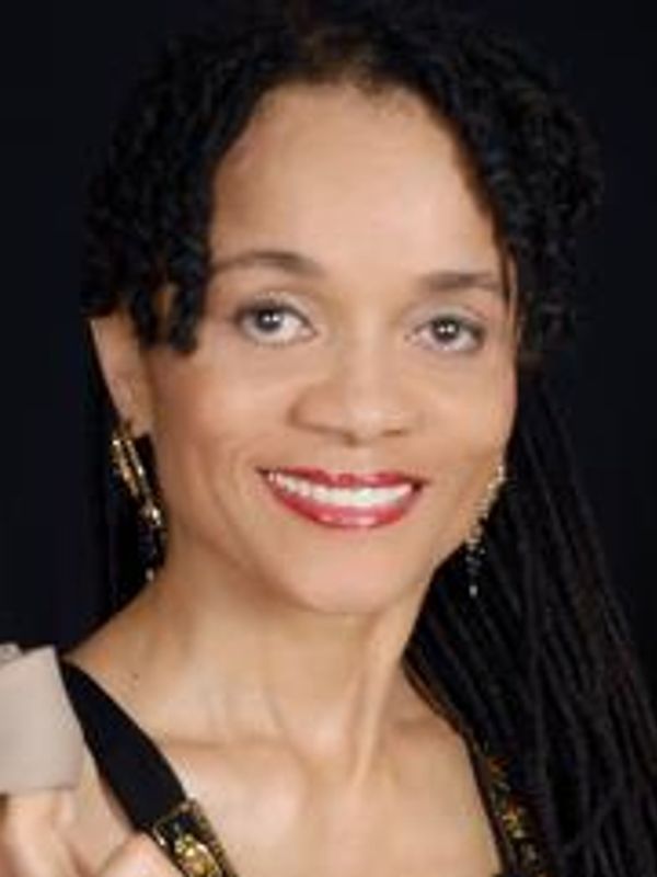 Portrait of a woman with curly hair and red lipstick smiling.