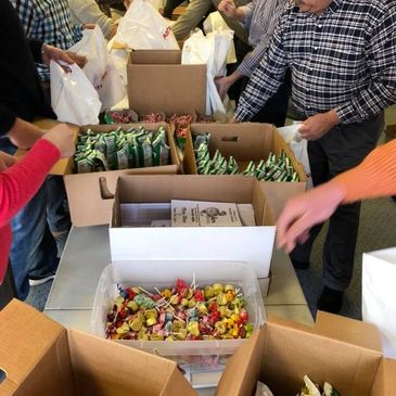 Volunteers stuff 600 treat bags for Santa to distribute after the Christmas parade.