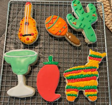A variety of cookies are arranged on the cooling rack.