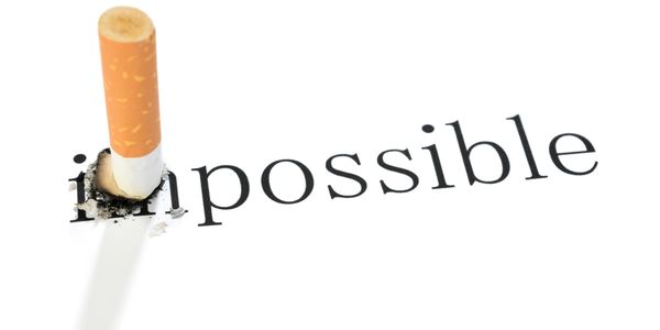 The letters I M from the word impossible are extinguished by a cigarette.