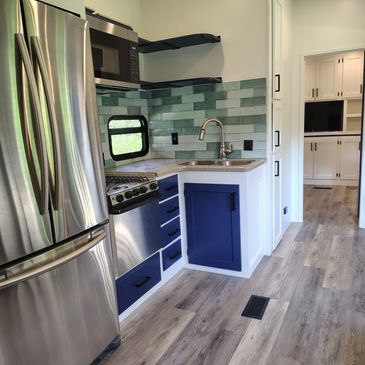 Modern kitchen with stainless steel appliances and blue cabinetry.