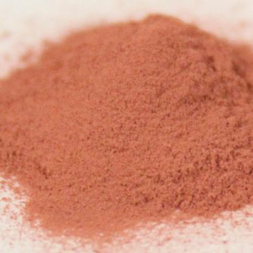A pile of fine reddish-brown powder on a light surface.