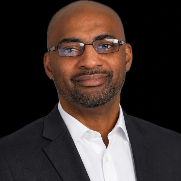 Confident man in a suit with glasses.