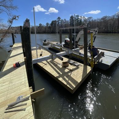 Wooden dock under construction over a river on a sunny day.