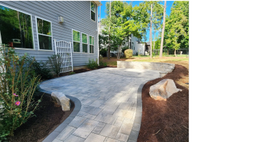 Spacious modern backyard patio with seating wall and landscaping Wake Forest NC