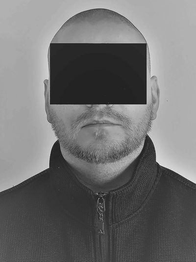 A private investigator with a black  rectangle concealing his identity/ facial features for privacy.