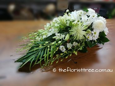 Mixed white and green flowers in a funeral sheaf created by a qualified florist