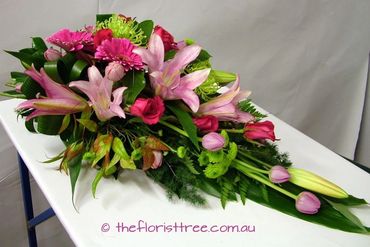 Funeral sheaf of pink flowers created by a qualified florist