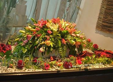 Lush casket funeral flowers created by a qualified florist