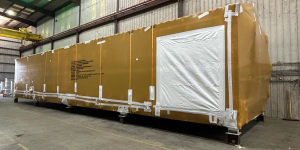 Large brown packaged crate inside a warehouse.