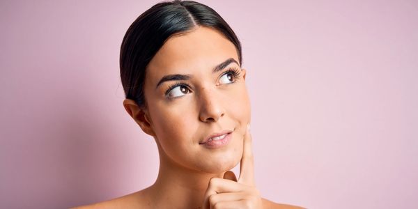 Young woman looking off into the distance with a curious look upon her face, possibly thinking.