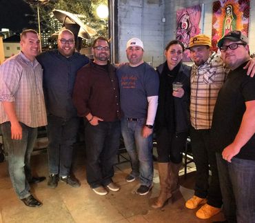 seven people casually dressed standing together to take a picture