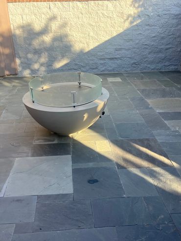 Natural slate patio with modern fire bowl in a walled courtyard.