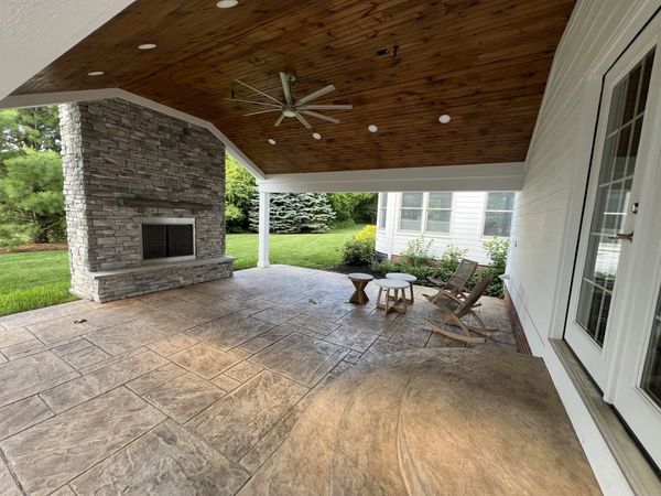 Covered patio with stone fireplace and ceiling fan!