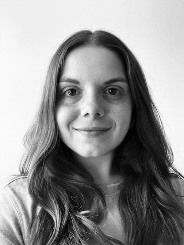 Black and white portrait of a young woman with long hair smiling gently.