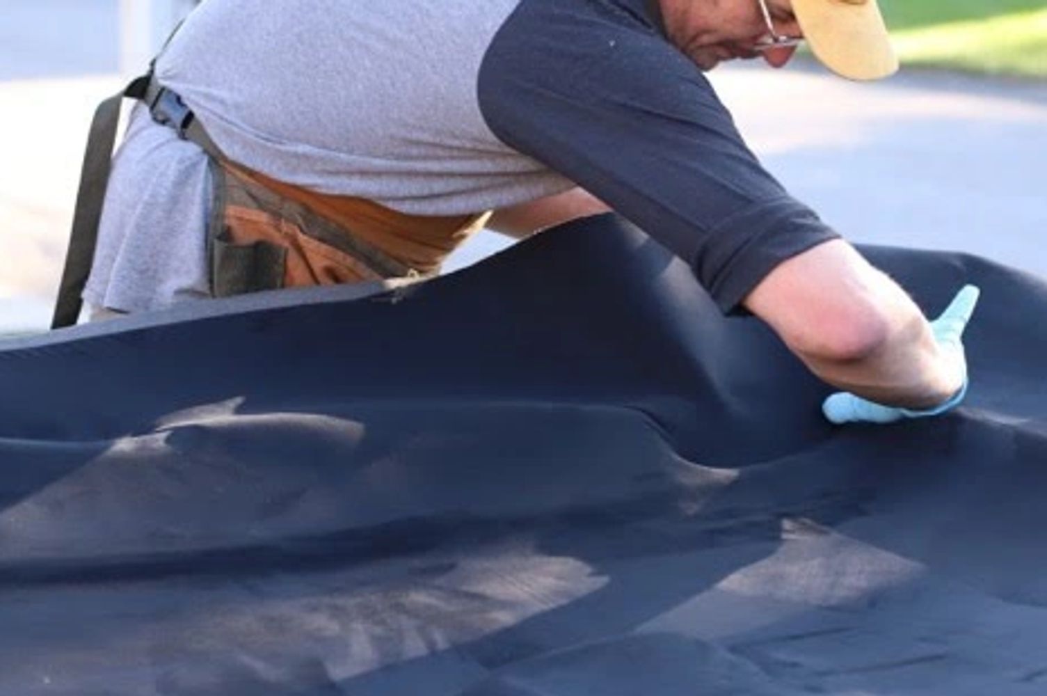 business owner working on a suede headliner.