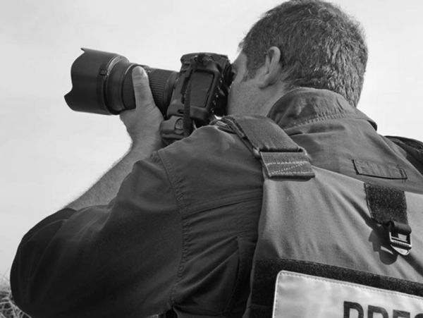 Photographer using a professional camera outdoors.