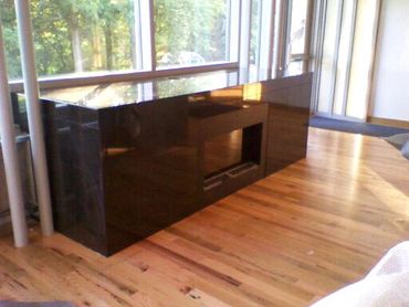 Black waterfall-edge countertop with a built-in fireplace.