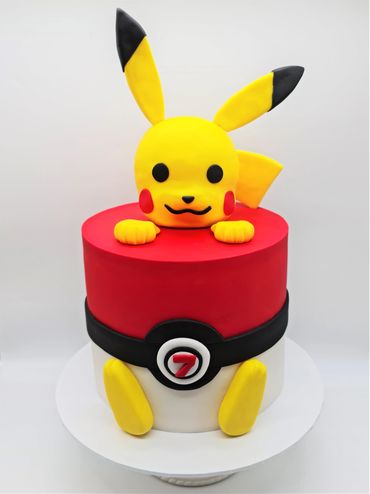 Cake designed like a pokeball. Pikachu is popping out of the cake.