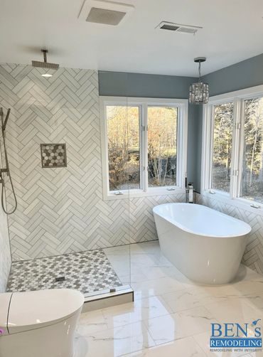 a remodeled bathroom by Ben's Remodeling with a walk-in shower, stand alone tub, white marble floor