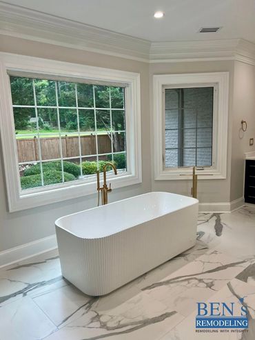 master bathroom by BEN's Remodeling with stand alone tub, white marble tiles, gold finishing
