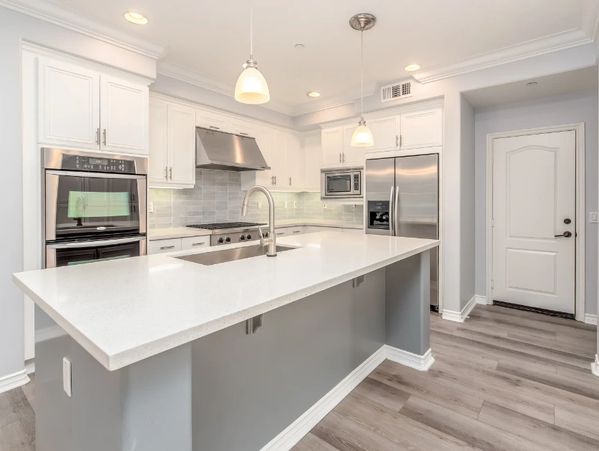 remodeled kitchen with white cabinets and  white counter top island 