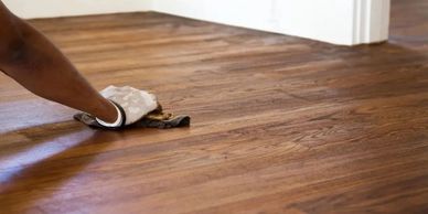 a craftsman staining a hard wooden floor