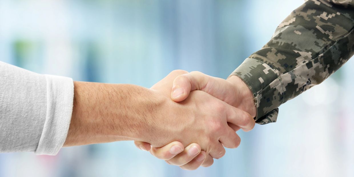 someone shaking the hand of someone in the military