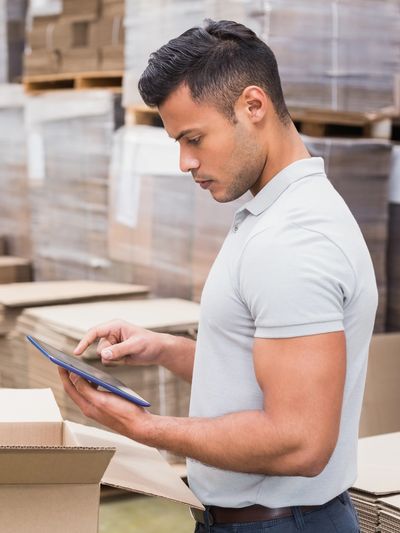 manager using digital tablet in warehouse