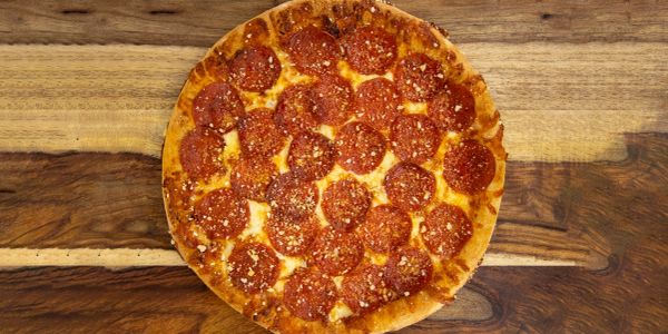 A pepperoni pizza with parmesan cheese.