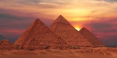 The Pyramids of Giza at sunset with a colorful sky.