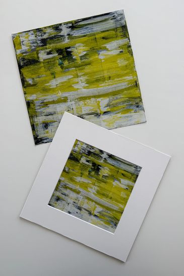 Two prints of the same art; yellowish green with black and whiteish pulls of messy color throughout.