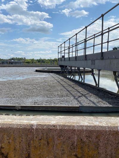 Water treatment facility with gravel bed and metal railing.
