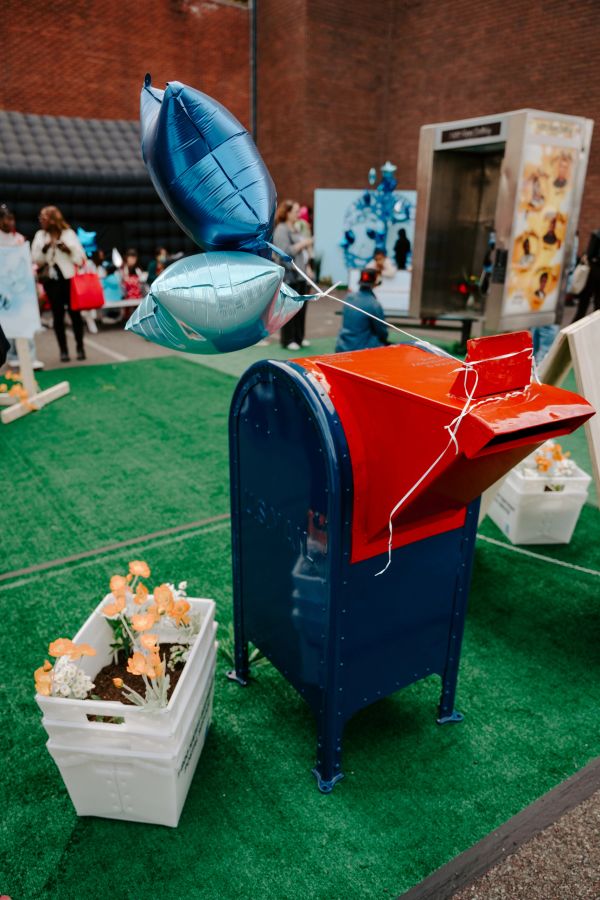 Blue balloons tied to a mailbox in a festive outdoor setting.